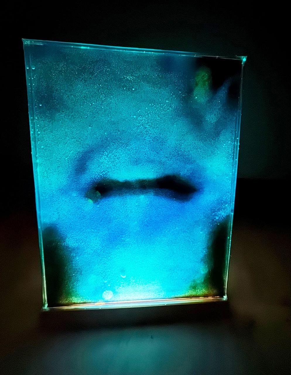 A face dissolving into turquoise light